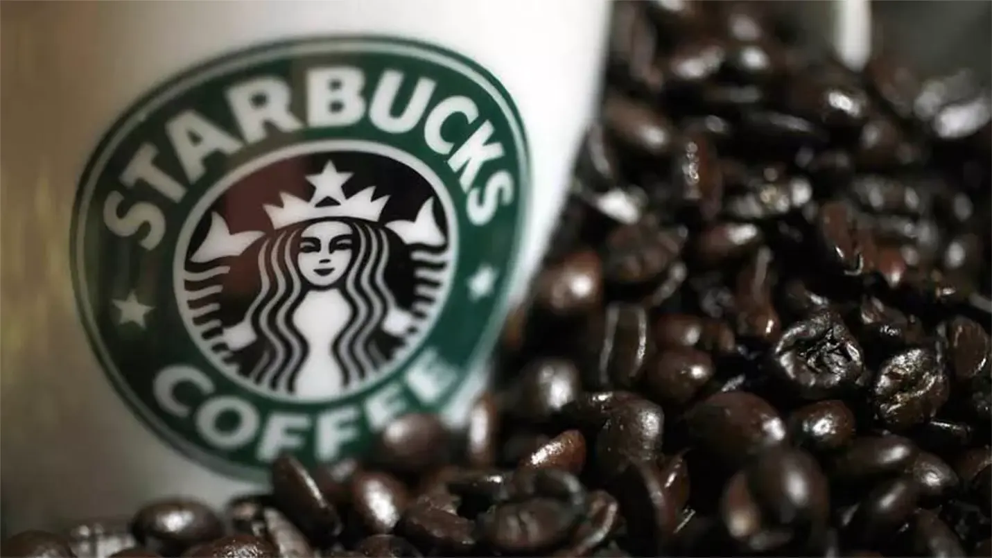 Starbucks coffee cup surrounded by fresh coffee beans