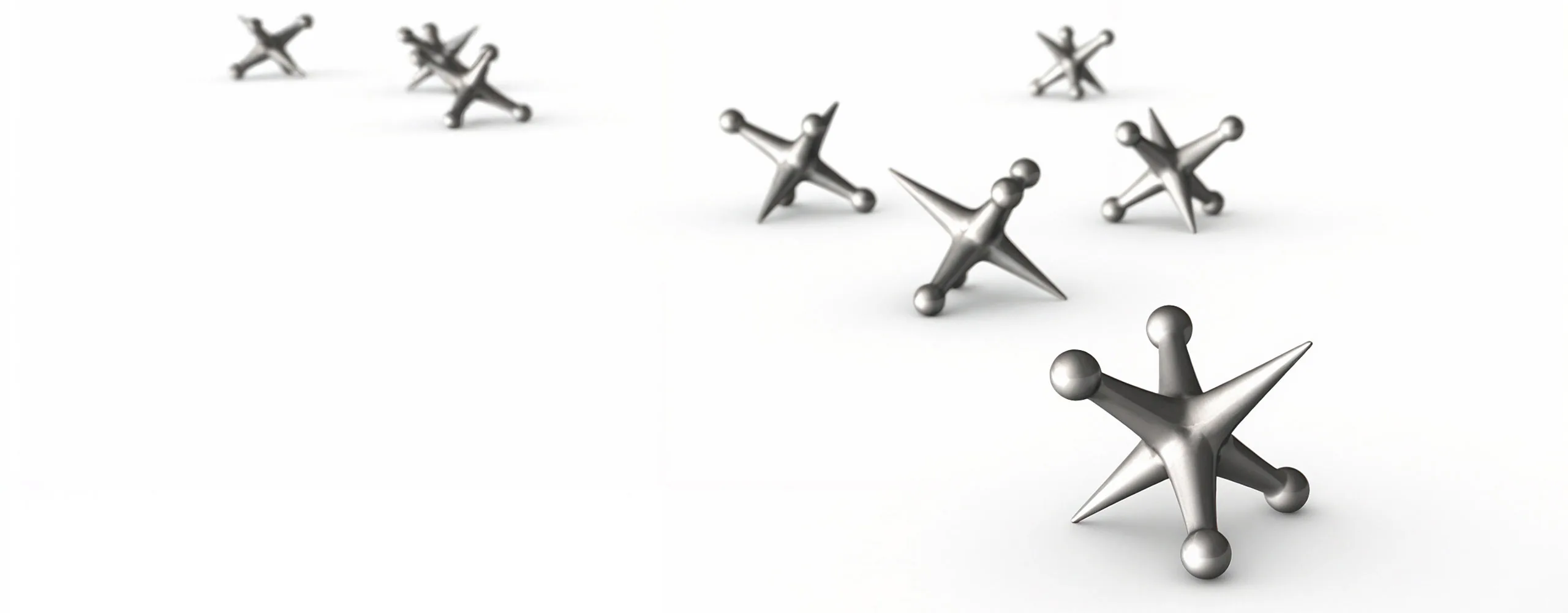 Polished metal jacks scattered across a white surface